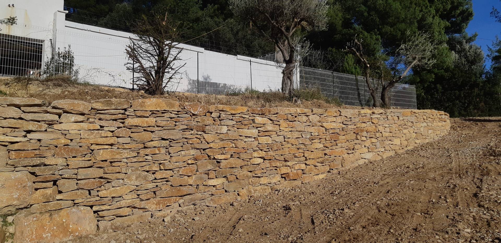 Création d' une route avec la construction d' un mur en pierres sèches pour la construction d' une maison neuve à Ollioules