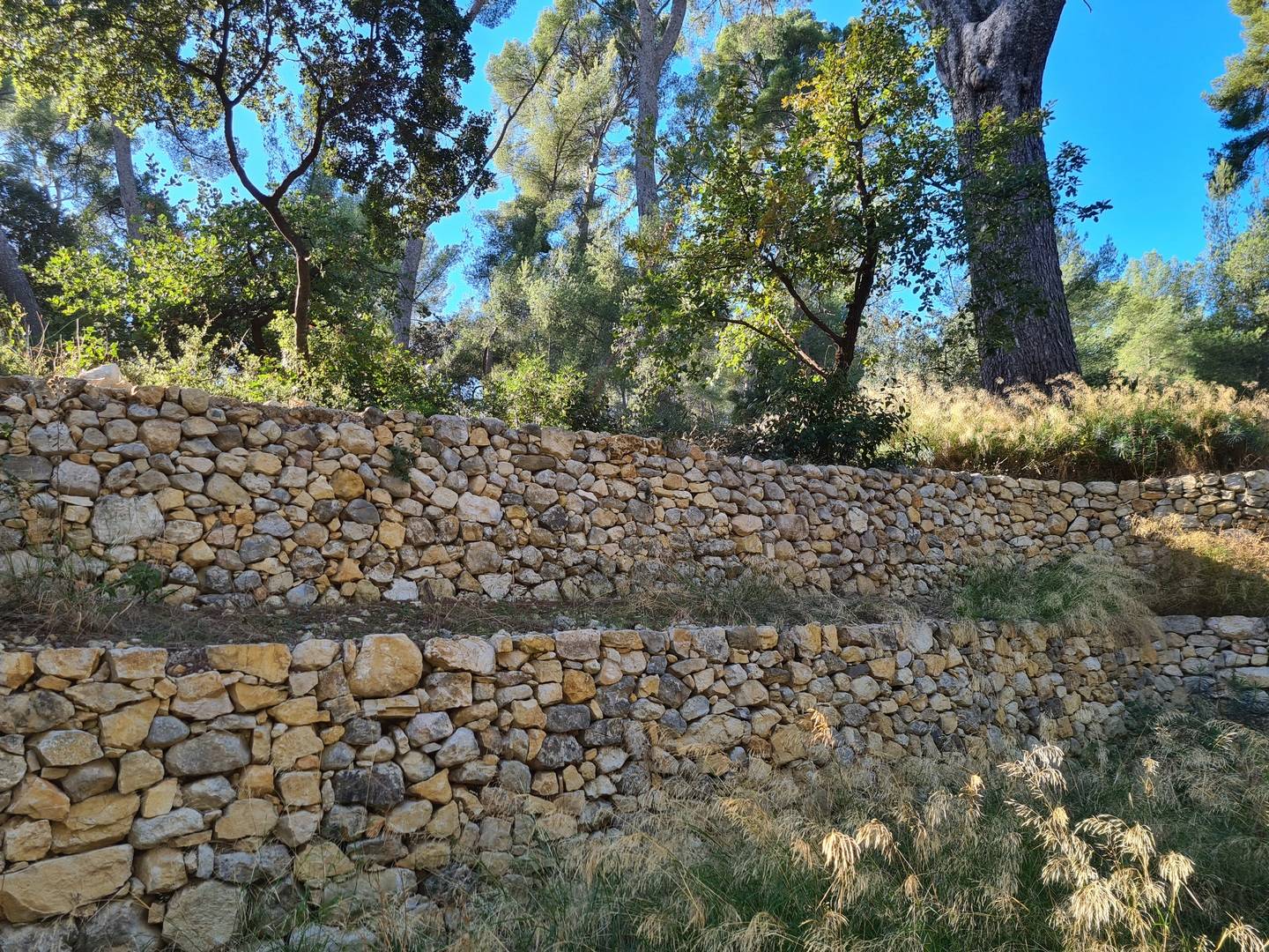 un mur en pierres sèches reconstruit avec les pierres trouvés sur place . 