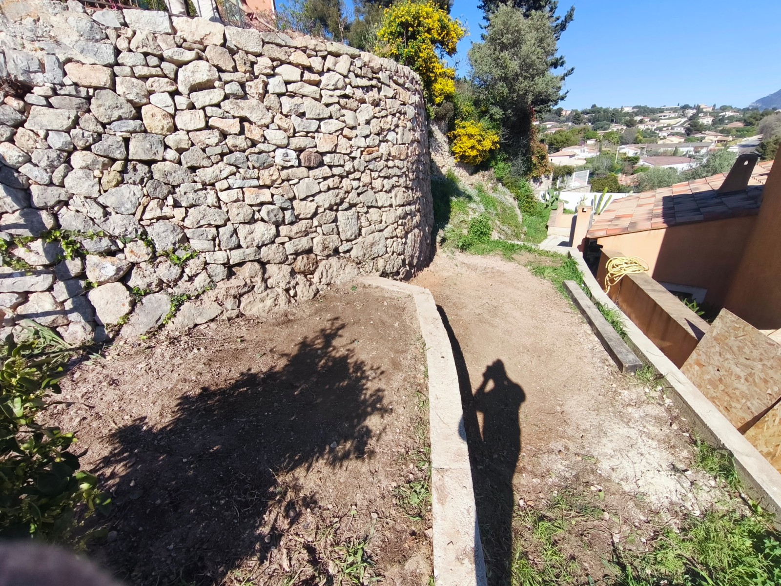reconstruction d'un mur en pierres sèches éboulé par les pluies 