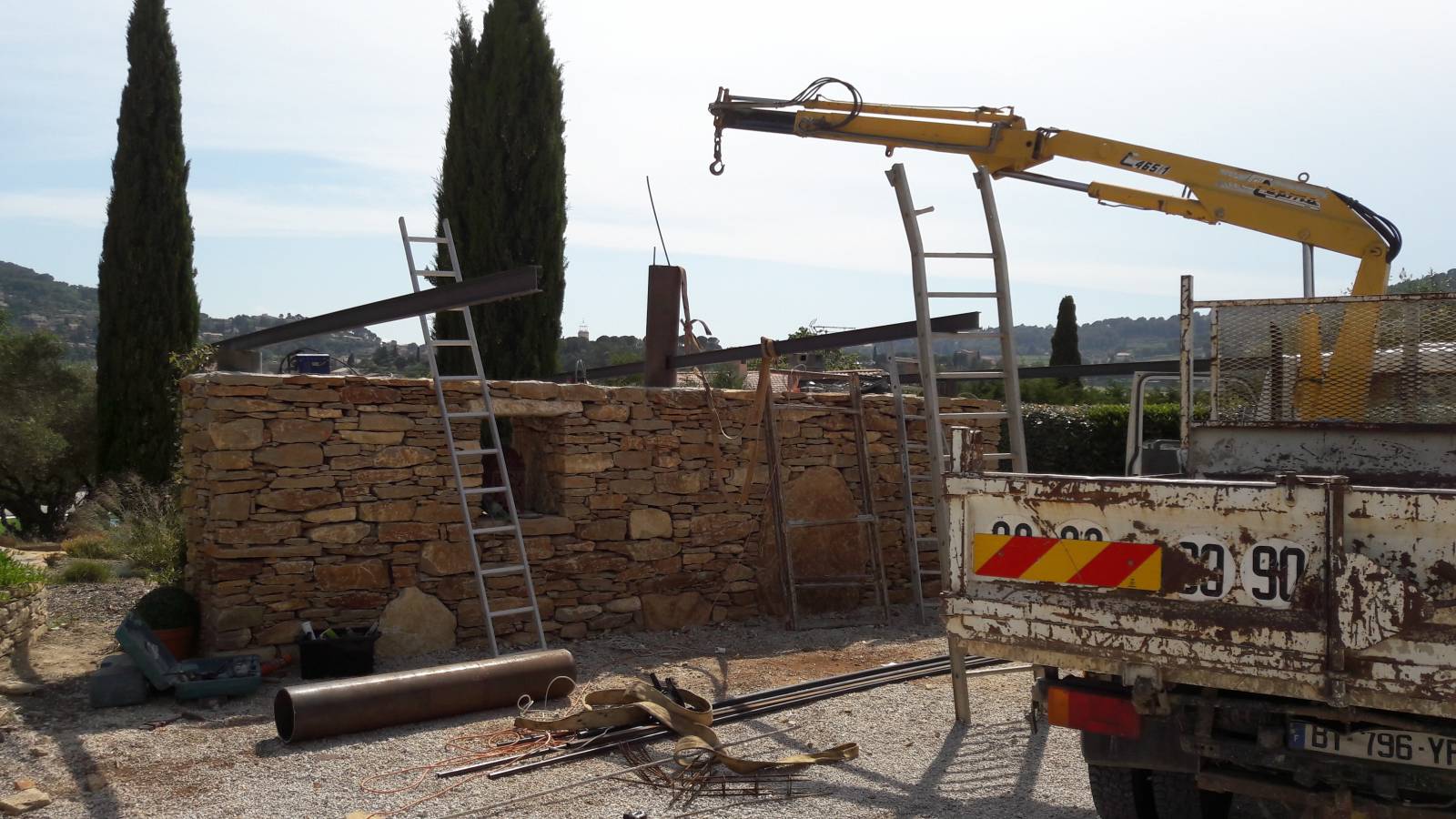 travaux de créations pour la conception d' un abris voiture avec un mur en pierres et une pergolas suspendue  dans le Var prés de toulon