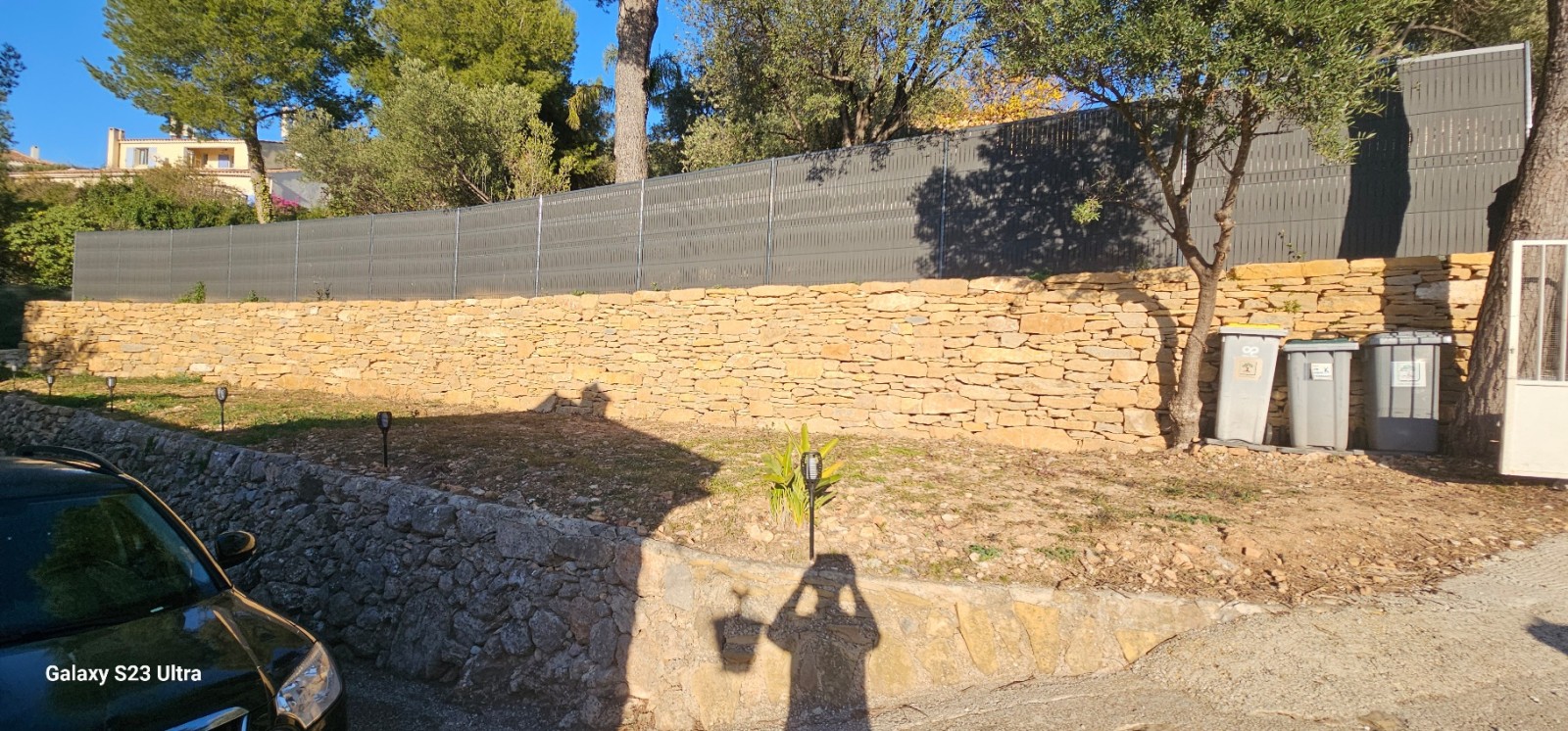 création d un muret de soutenement en pierres séches avec une clôture grillage et pose occultant