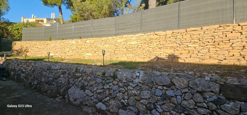 création d un muret de soutenement en pierres séches avec une clôture grillage et pose occultant