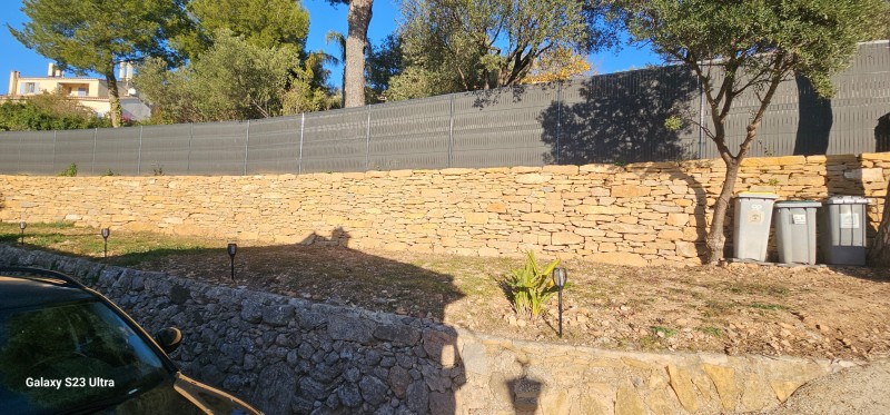 création d un muret de soutenement en pierres séches avec une clôture grillage et pose occultant