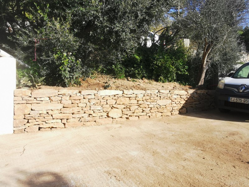 Création d'un muret en pierres sèches sur un parking voitures