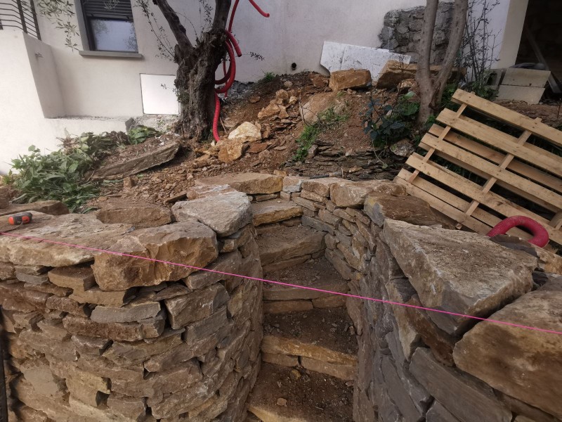 Construction d'un muret en pierres sèches avec un escalier dans le var