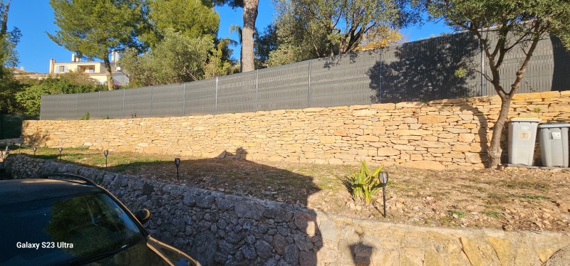 création d un muret de soutenement en pierres séches avec une clôture grillage et pose occultant